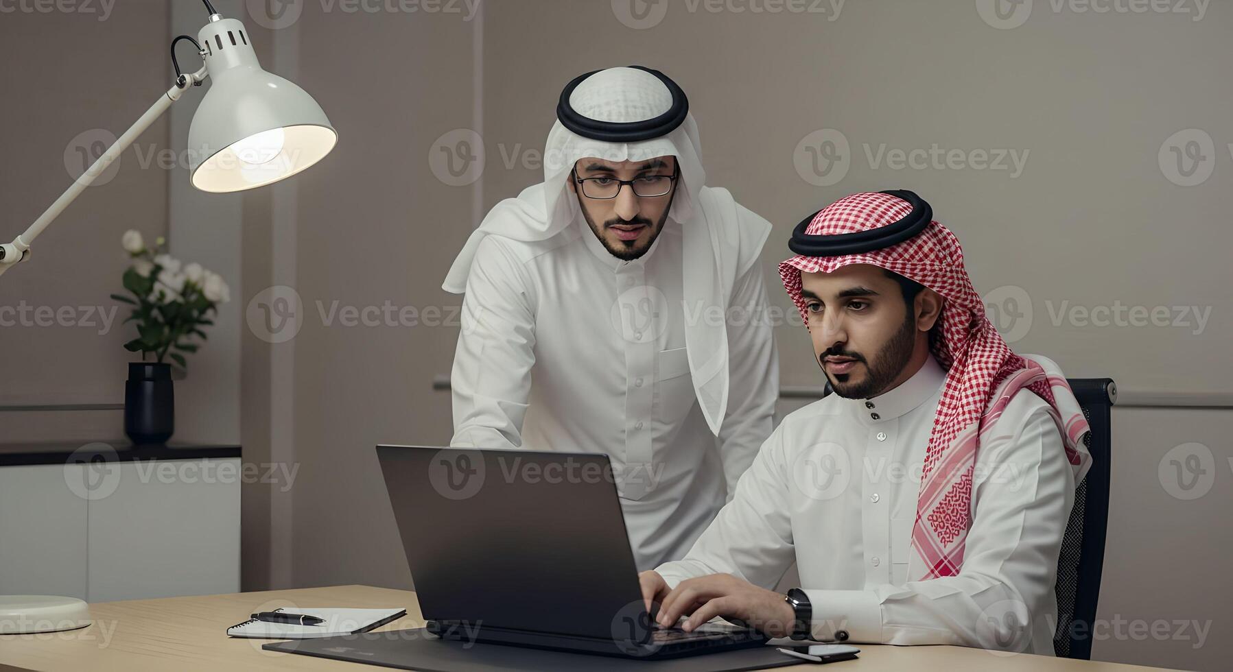 Two arab men collaborating on business task using laptop computer in modern office. Professional workplace and team working concept photo