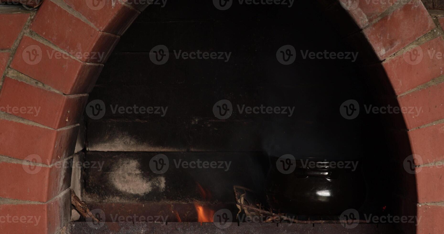 Clay pot placed inside rustic oven with vibrant flames growing steadily, showcasing traditional cooking techniques in an earthy environment that emanates warmth and comfort photo