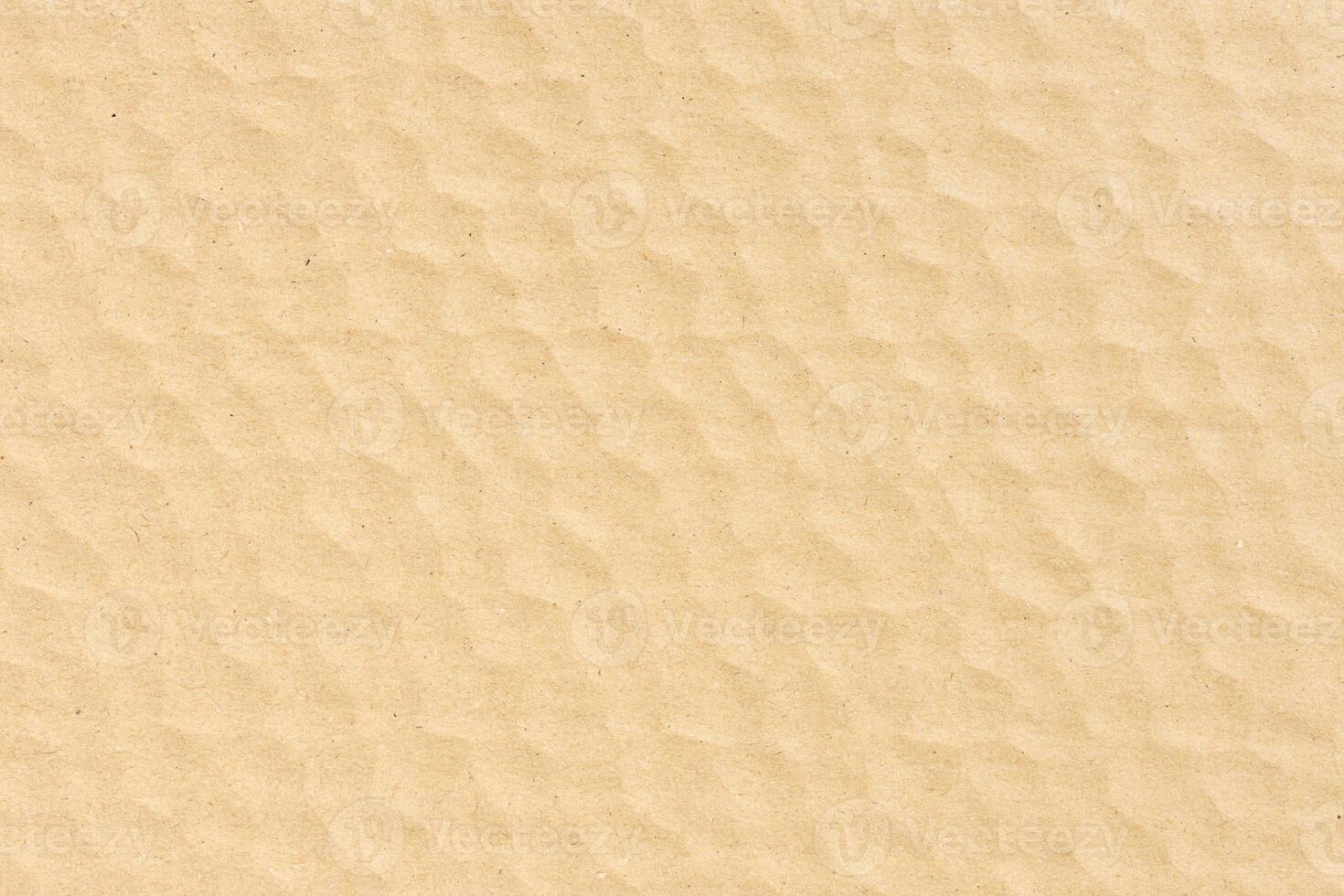 Abstract background of a brown textured cardboard forming a repeating pattern. Full frame photo