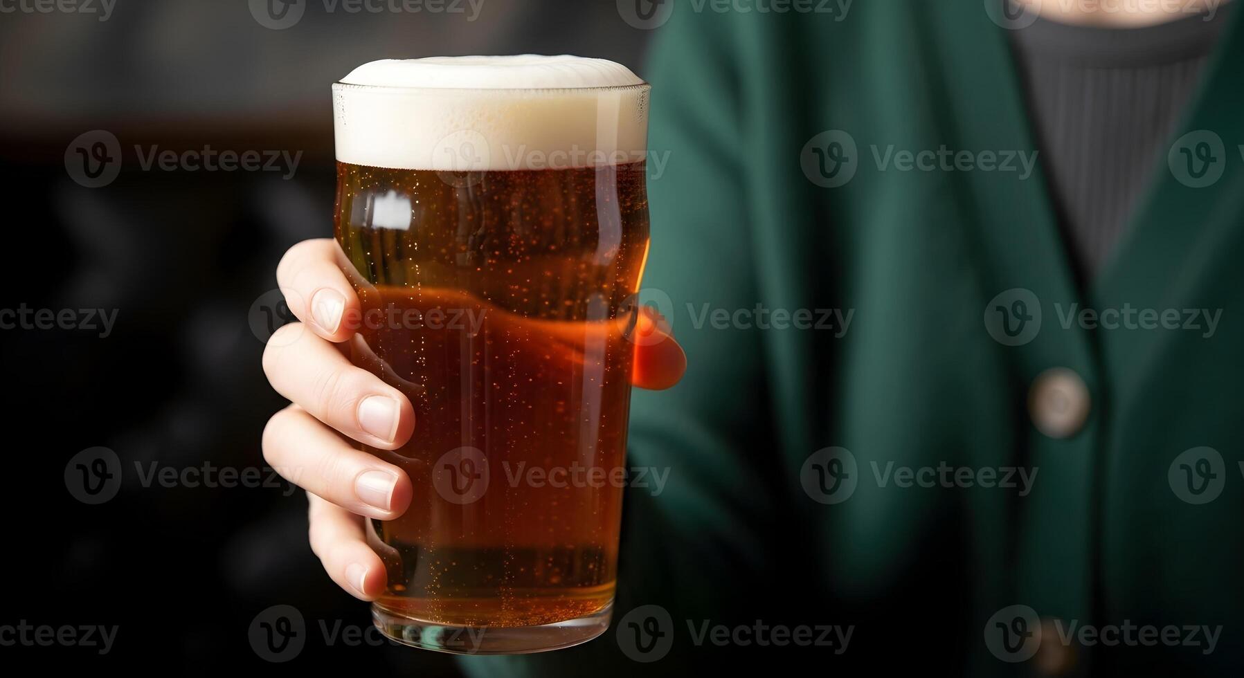 Female hand in green holds a glass of fresh light beer and extends it to the camera. Banner template for St. Patrick's Day, beer parties, Oktoberfest and beer factory advertising with space for text photo