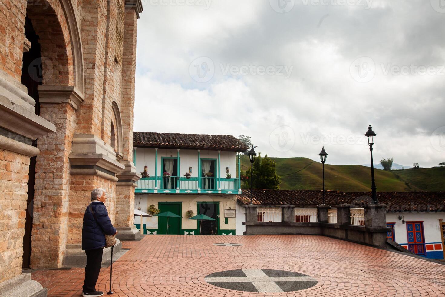Senior woman traveling concept. Buildings around the Jose Maria Cordova Park and Our Lady of the Immaculate Conception Church in the beautiful colonial town of Concepcion in Antioquia, Colombia. photo