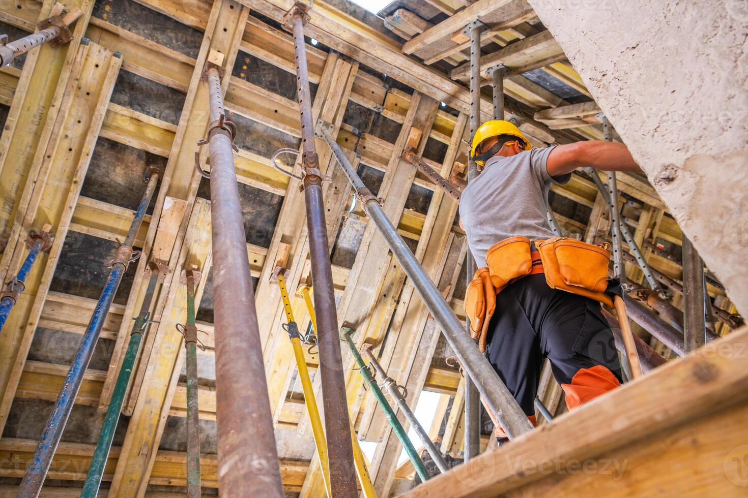 Construction Worker Performs Tasks on a High-Rise Building Site During Daylight Hours photo