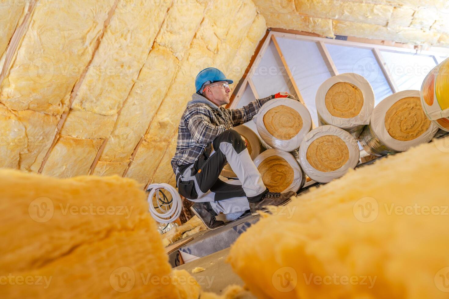 Worker Installing Mineral Wool Insulation in a Residential Attic During Daytime Renovation Process photo
