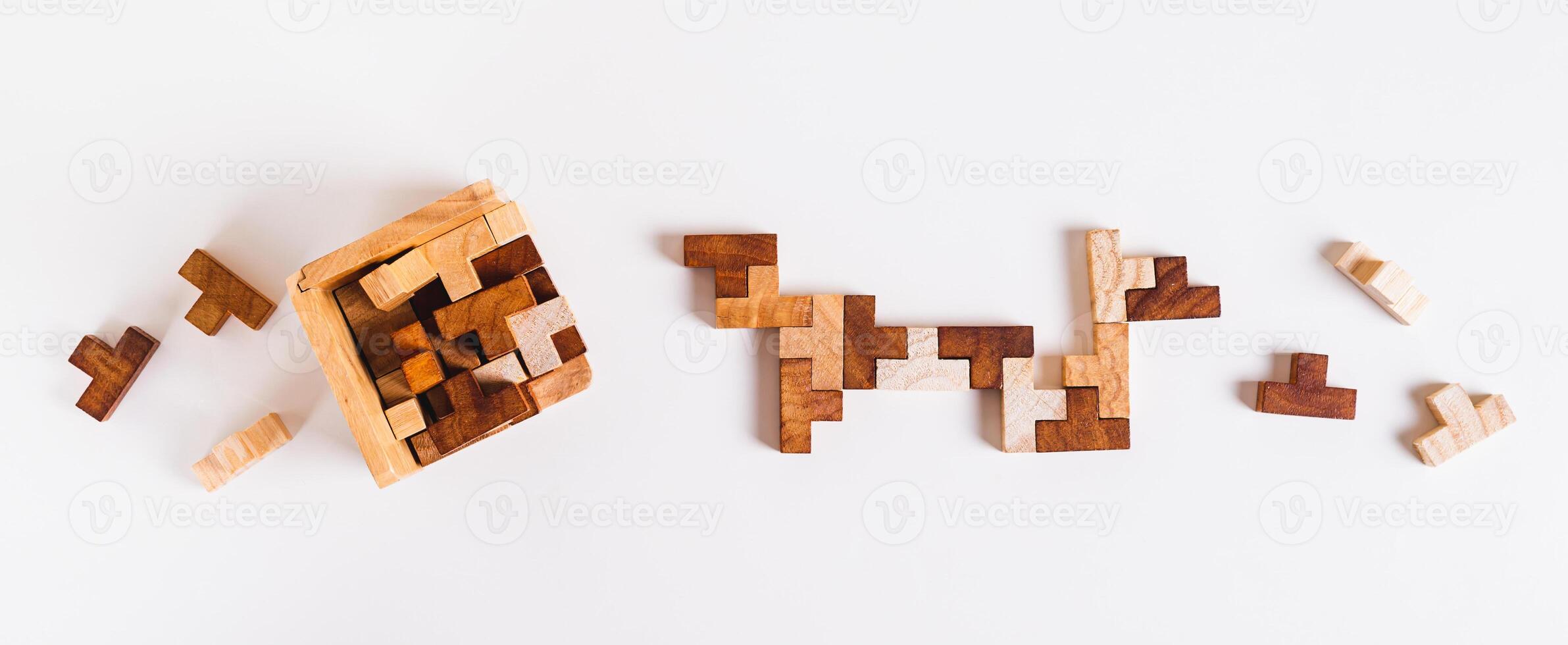 Wooden puzzle figures are folded into a box and between each other top view and web banner photo