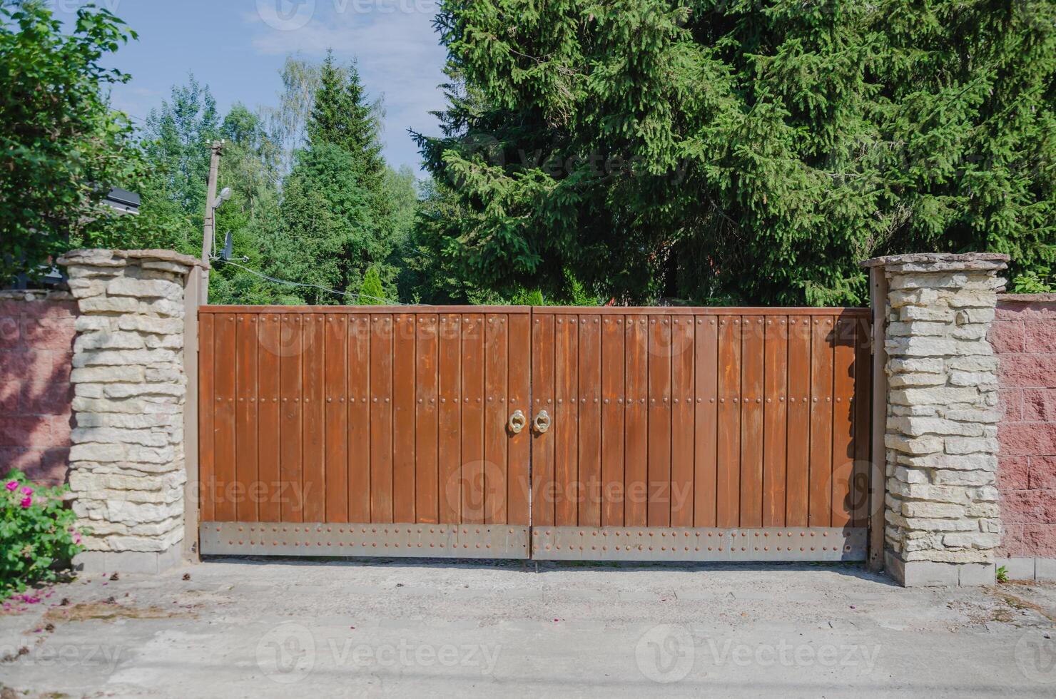 Wooden gate with round shiny handles, large gate for car entry. High quality photo