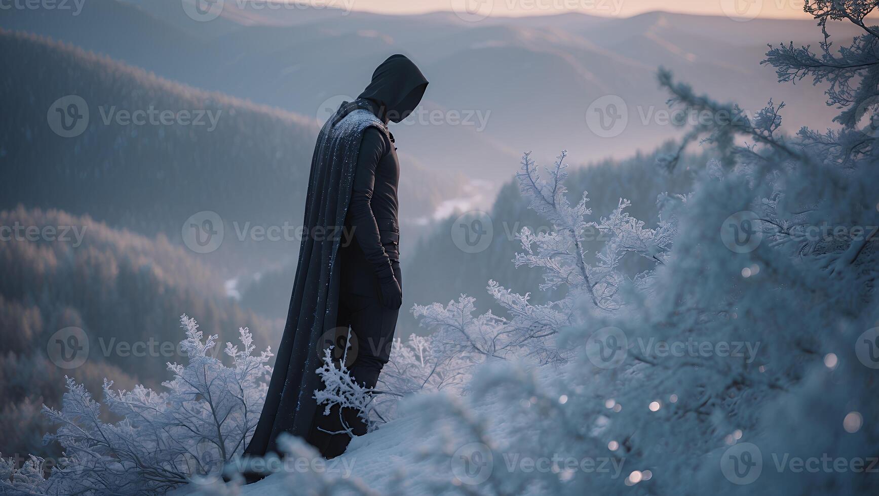 Mysterious figure in a dark cloak standing on a snowy mountain peak during dawn, overlooking valleys photo