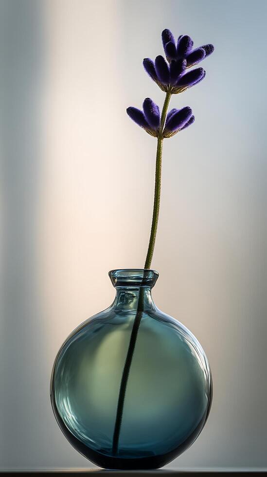 Single Lavender Sprig in a Blue Glass Vase Bathed in Soft Light. photo
