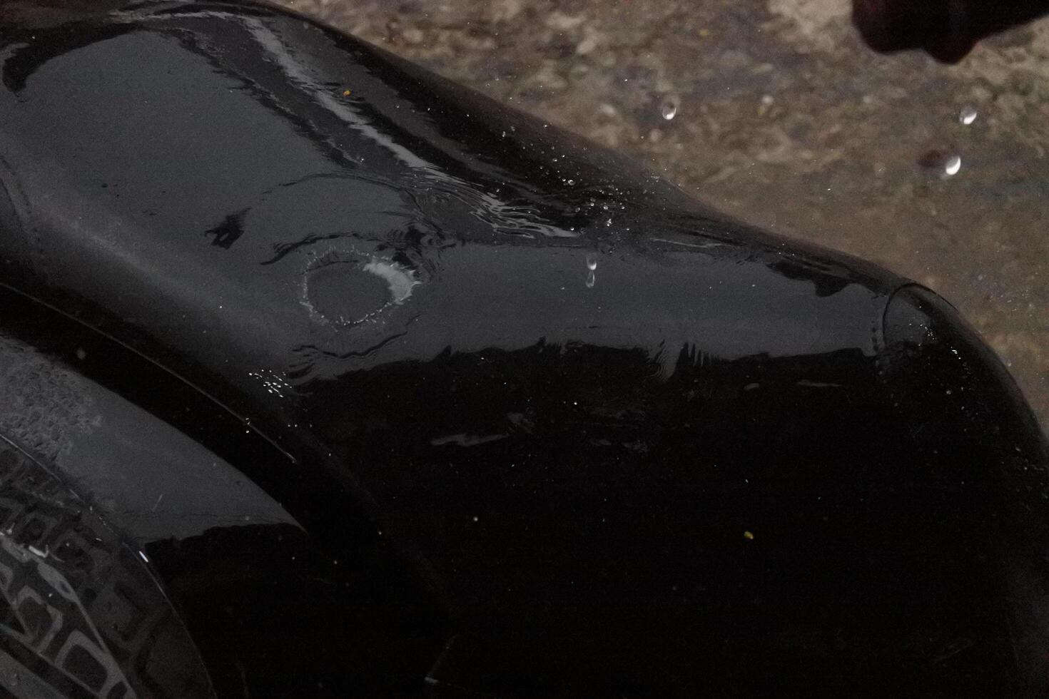Close-Up of a Black Surface with a Circular Mark During Rain photo