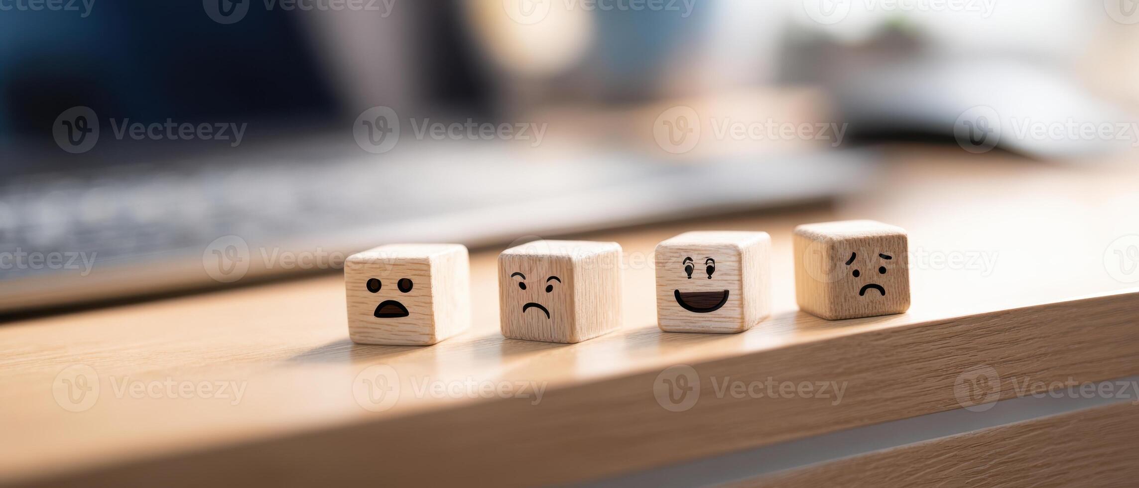 The collection of wooden blocks showcasing various emotional expressions on a desk. photo