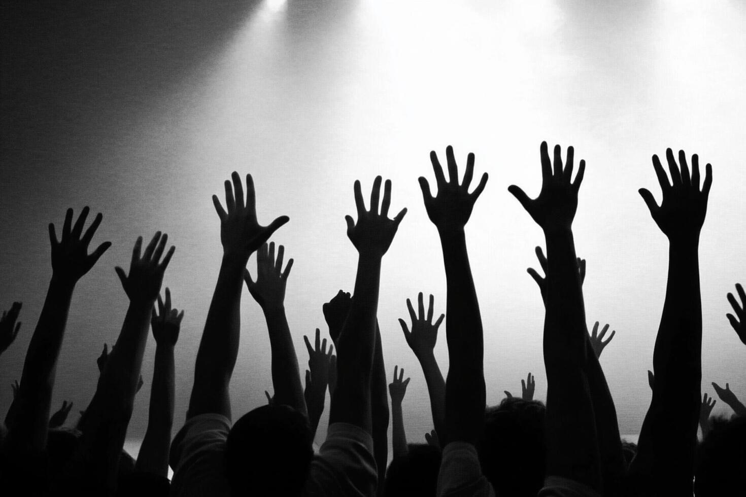 A crowd of people with their hands up in the air photo