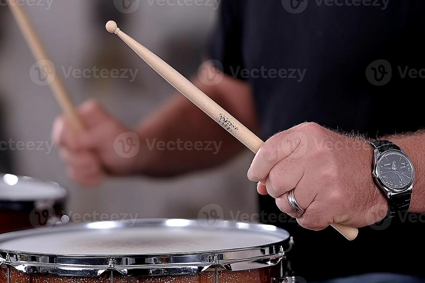 A man is playing drums with two sticks photo