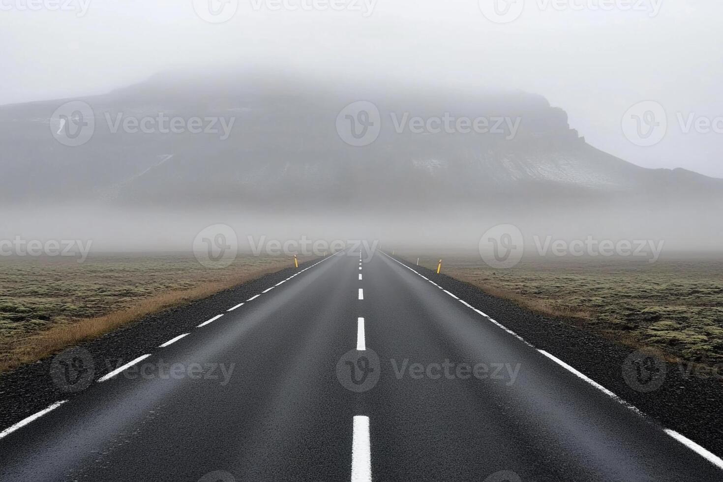 A long empty road in the fog with mountains in the background photo