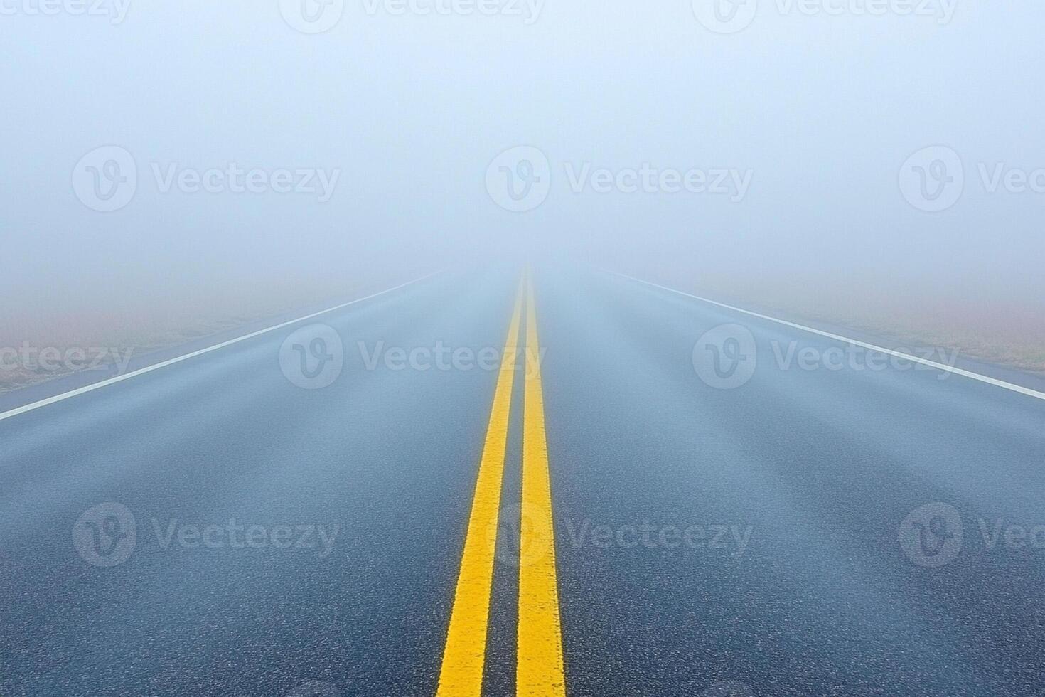 An empty road in the fog with yellow lines photo