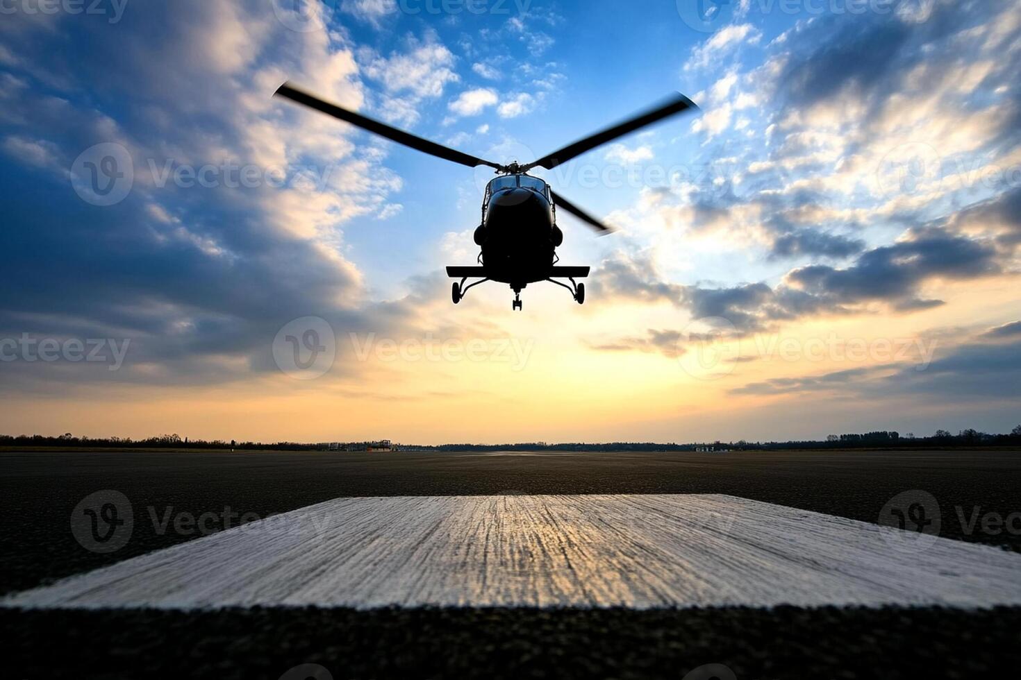 Helicopter landing on the runway at sunset photo