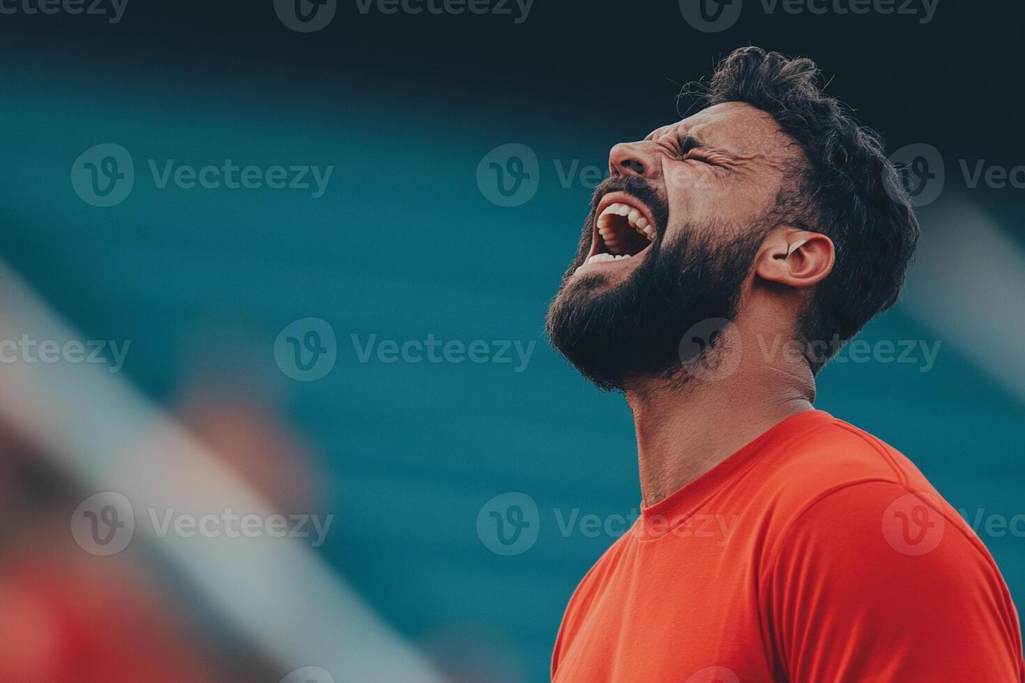A man with a beard and red shirt is yelling photo