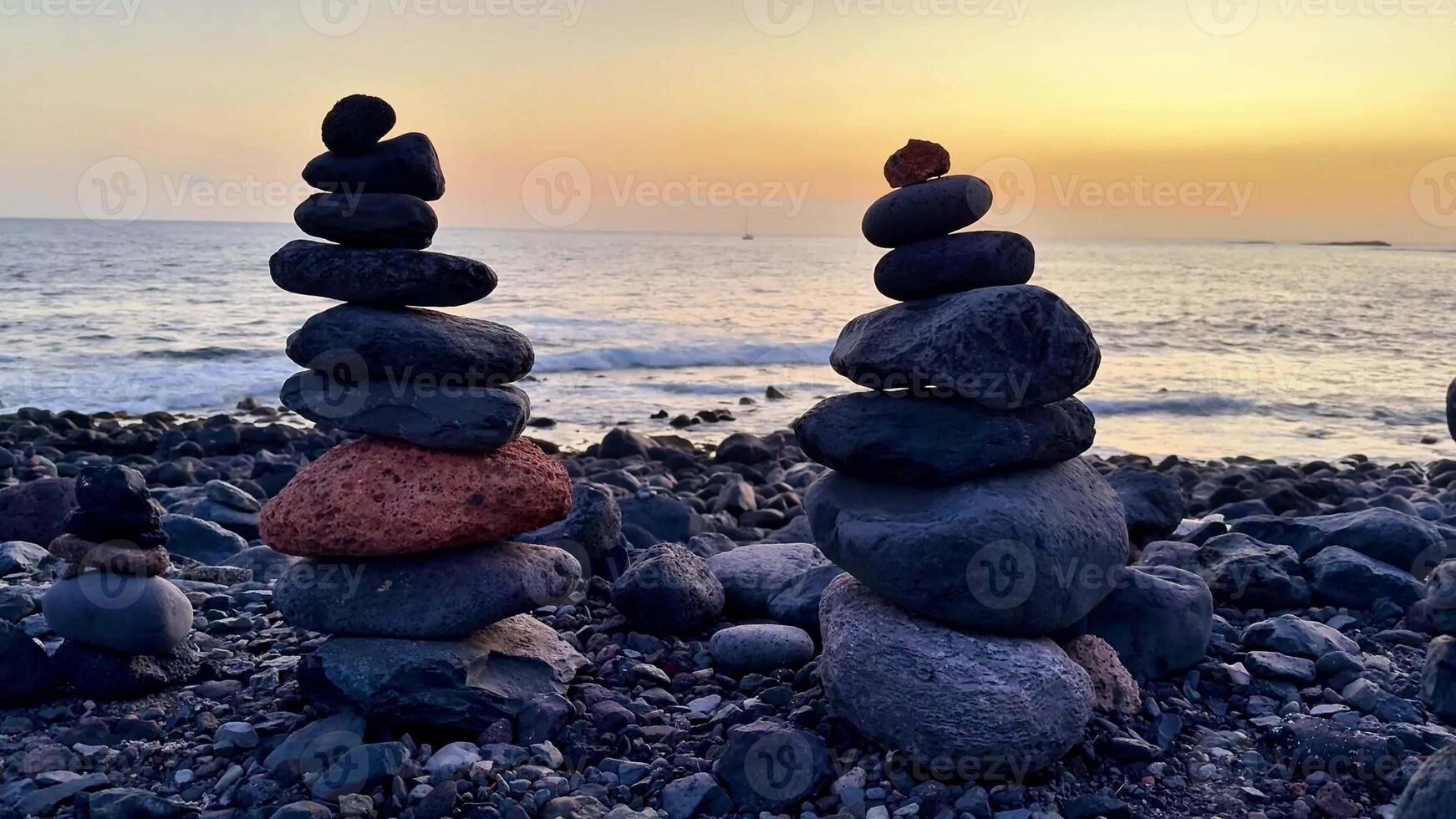 The beautiful stacked stones in harmony create a truly peaceful and calming scene at sunset by the oceans edge photo