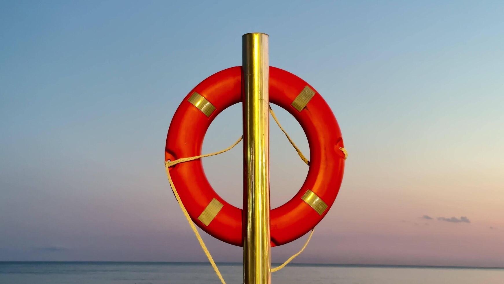 A Vibrant Lifebuoy Floating Against a Tranquil and Serene Seascape During Daylight photo