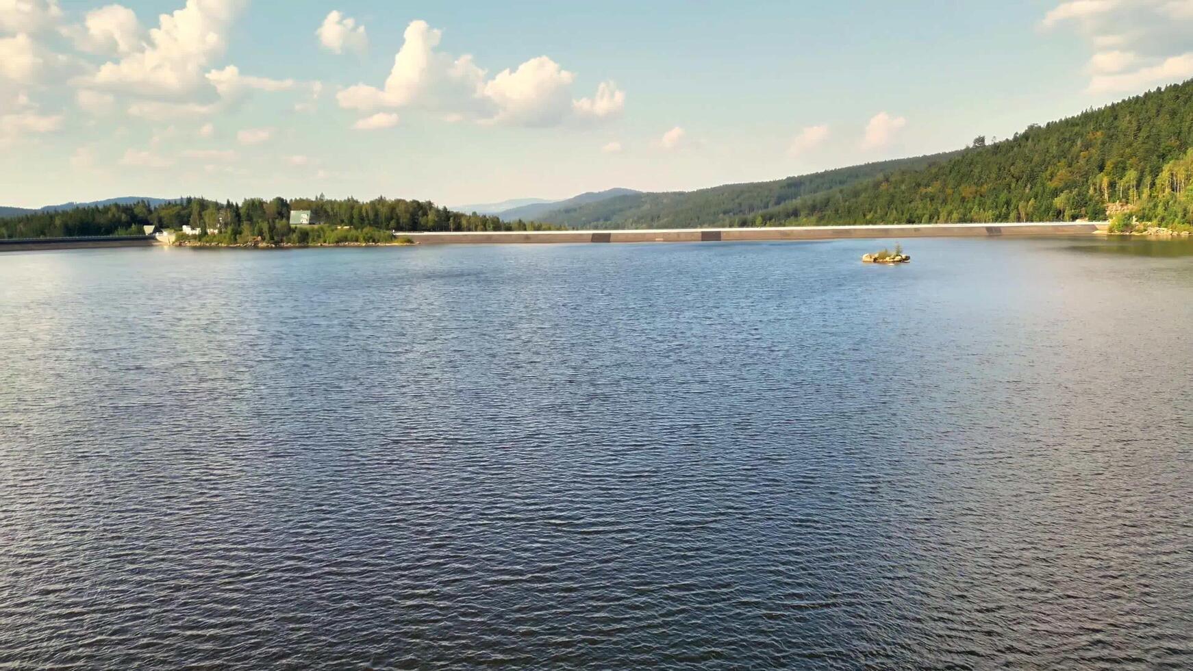 A view of a serene and calm lake set against magnificent mountains and beautiful clouds photo
