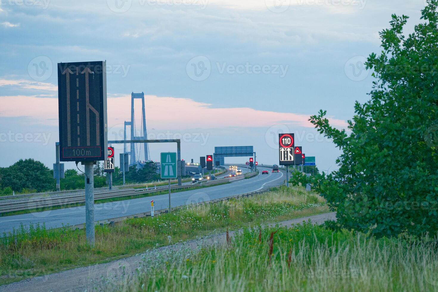 The Oresund OEresund Bridge viewed from the east side near Korsor in Denmark at dusk with many signs photo