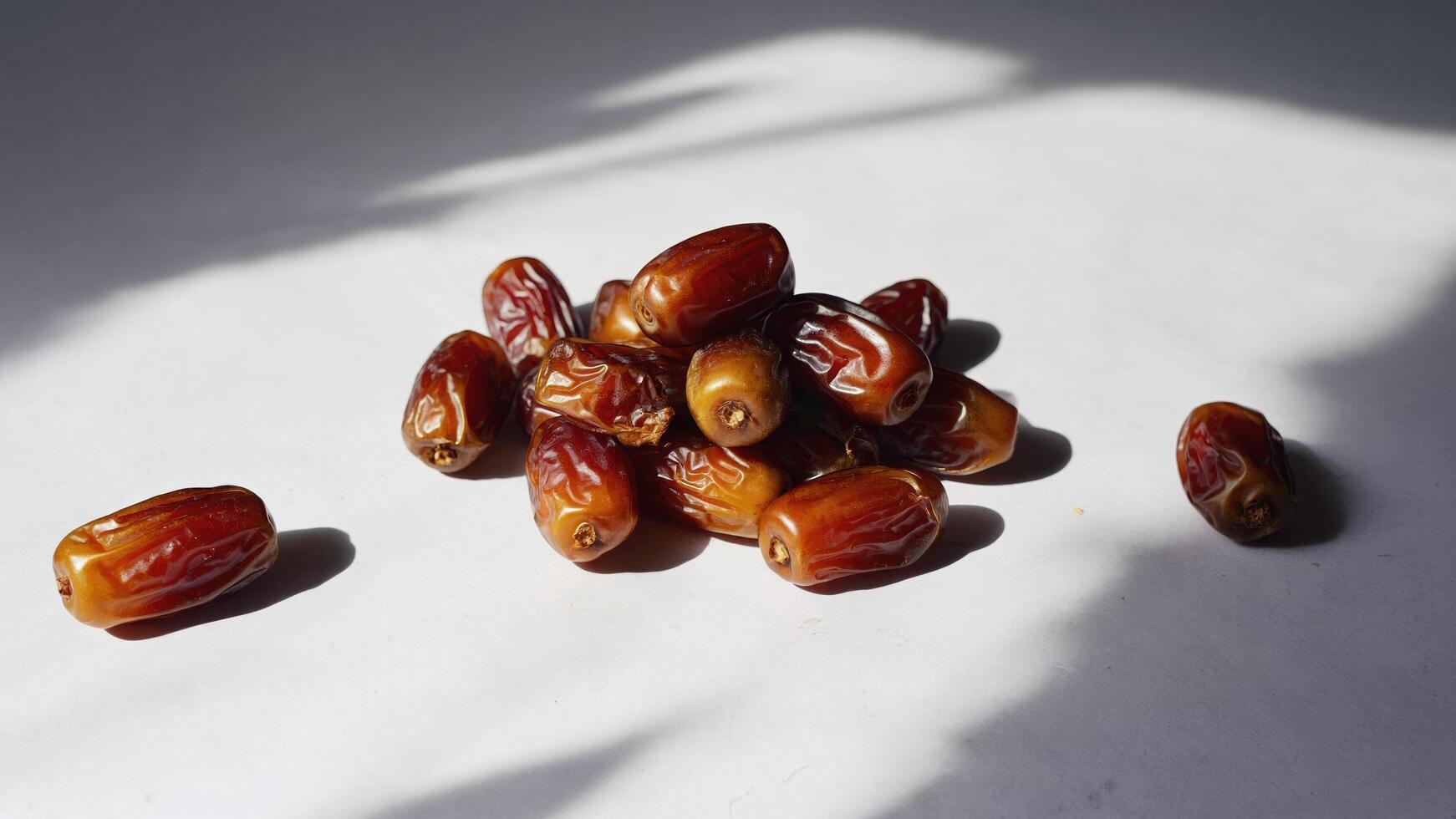 Pyramid of dates on a white background with shadows. Some dates are separate from the main group. The perfect still life for culinary and food projects. photo