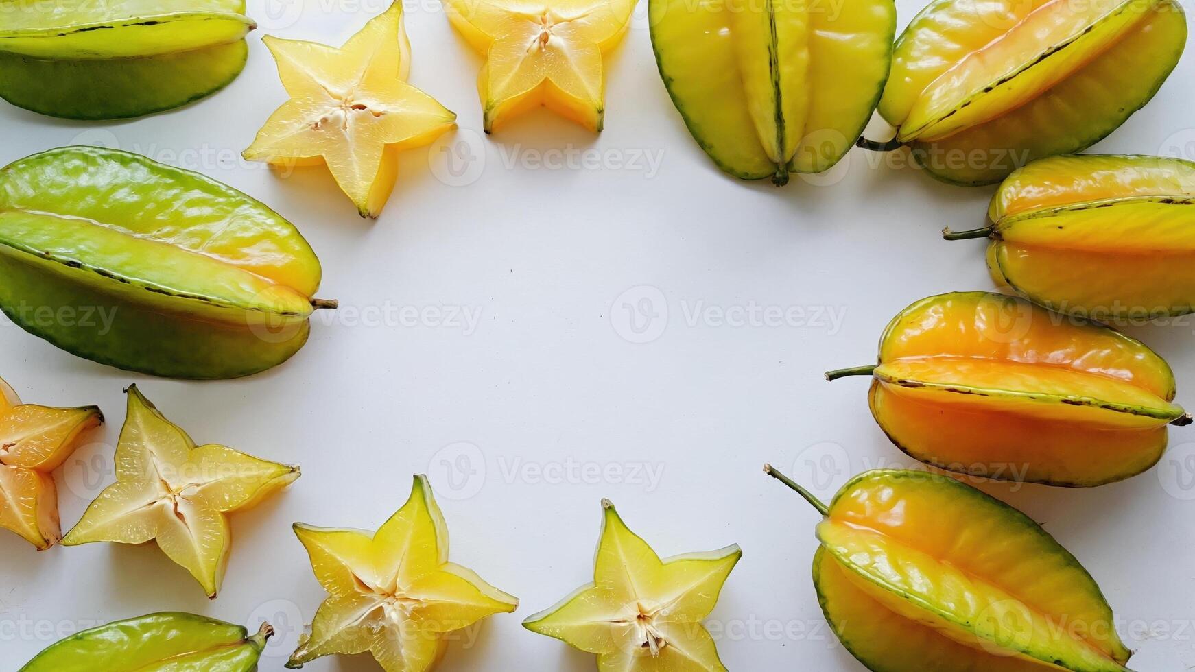 Carambola fruits are of different colors green and yellow, as well as sliced in the form of stars. Bright fruits on a white background create an appetizing and exotic look. photo