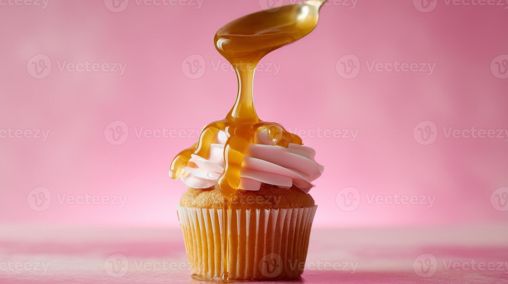 A Delicious Cupcake with Sweet Caramel Drizzle displayed beautifully on a Pink Background photo