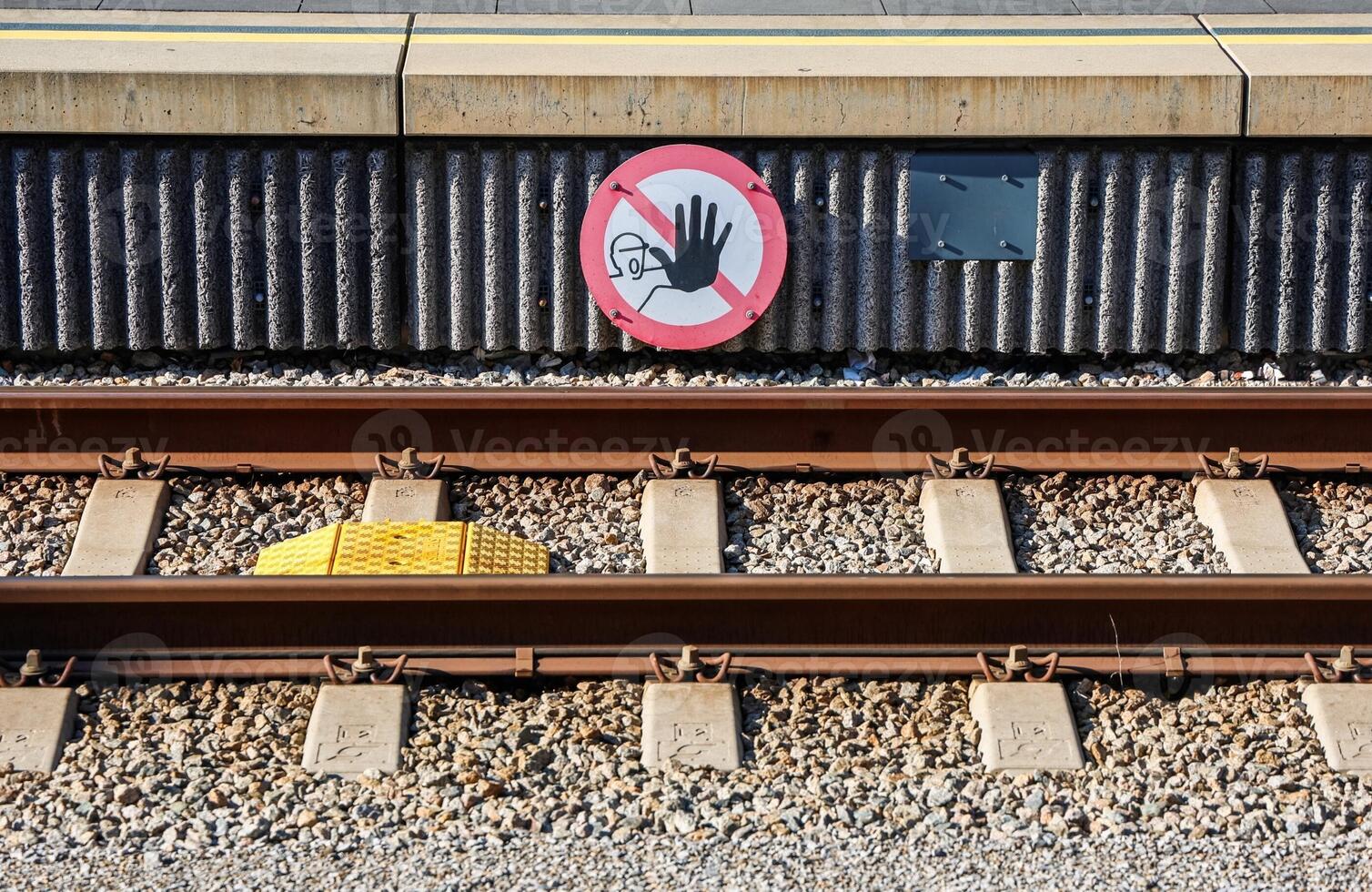 Do not cross, railway tracks and warning sign at station platform photo