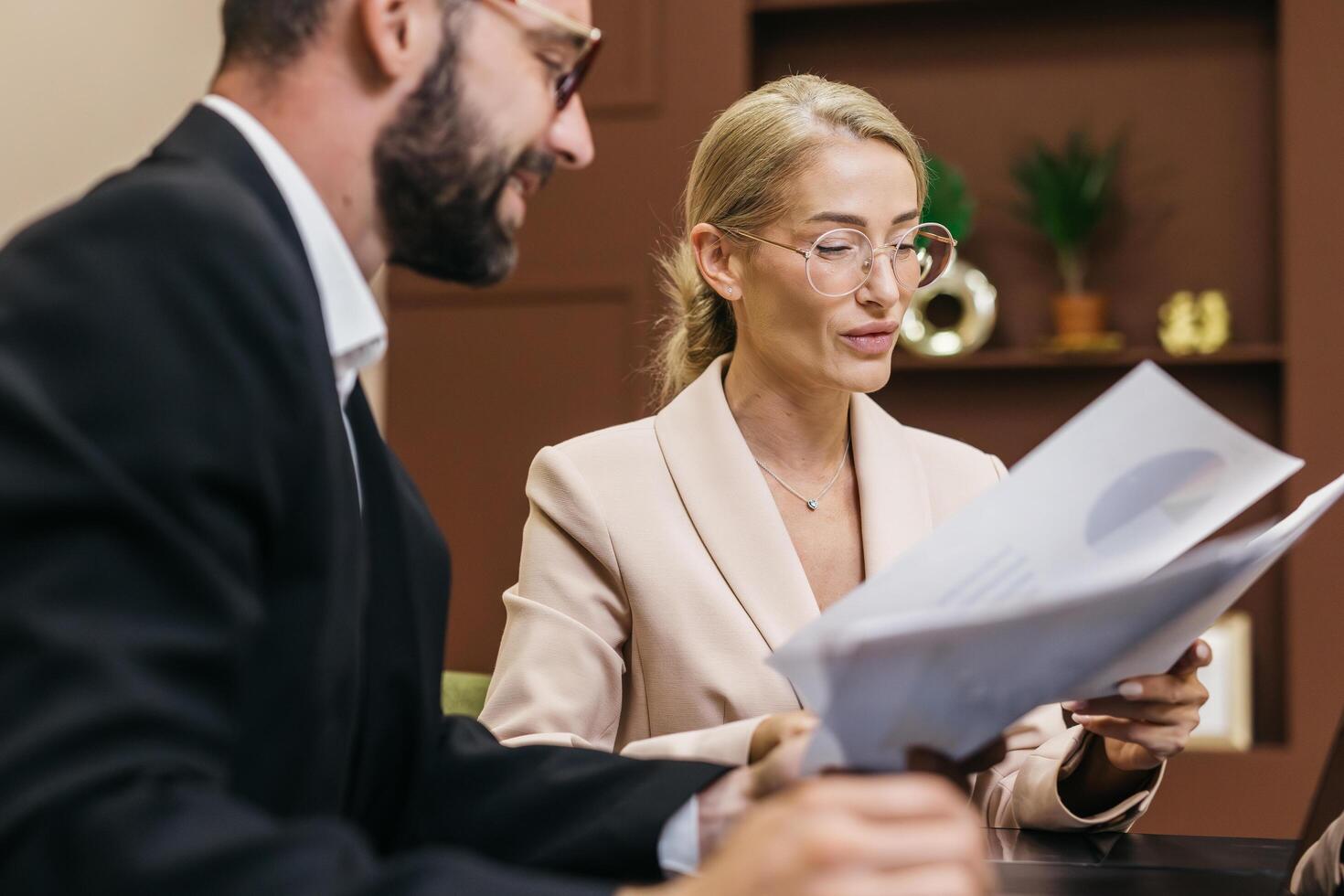 Business professionals engaged in strategic planning, reviewing financial charts and documents, showcasing collaboration and teamwork in a modern office environment with a focus on innovation photo