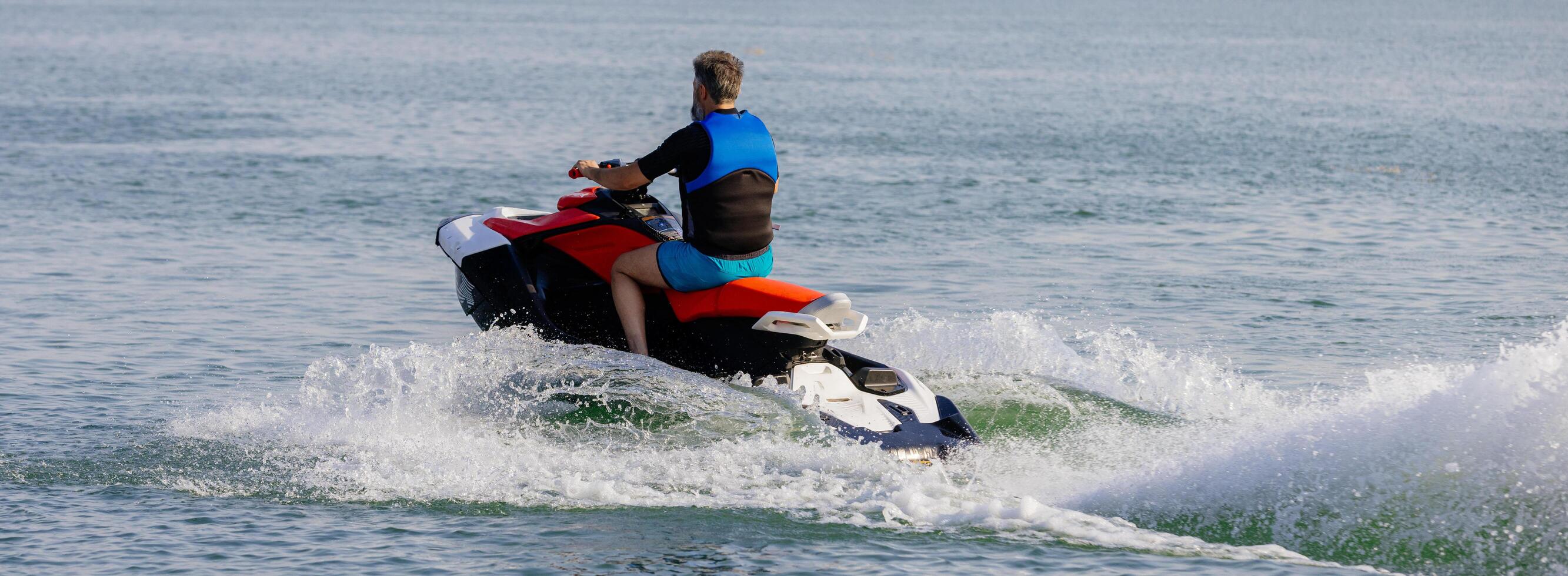 A man speeds on a jet ski, skimming the water surface and creating powerful splashes with every turn. photo