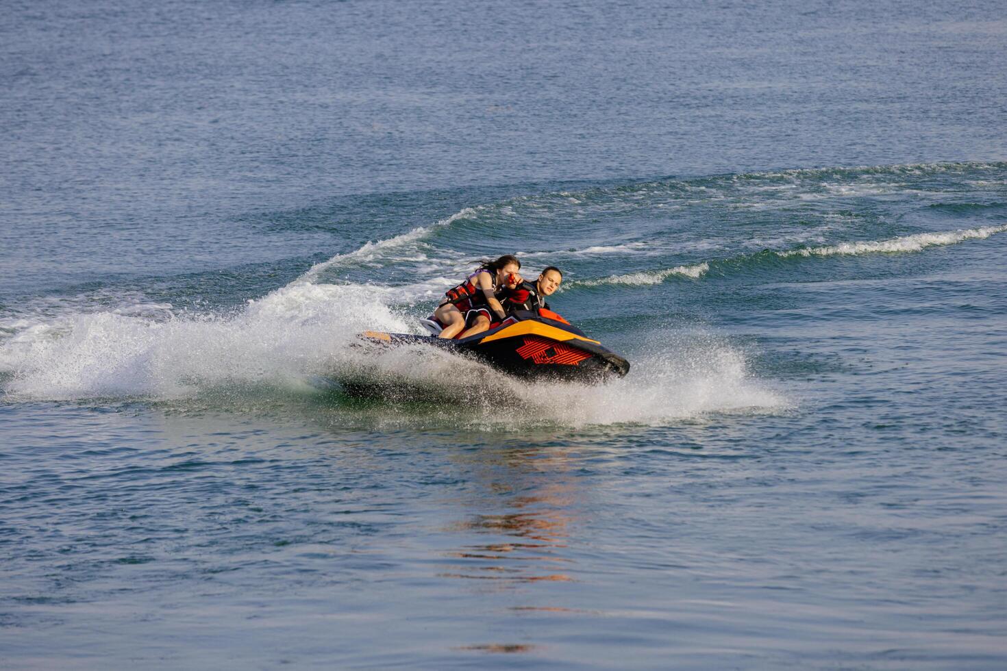 Happy couple riding a jet ski. Concept joy, freedom, and shared adventure. photo