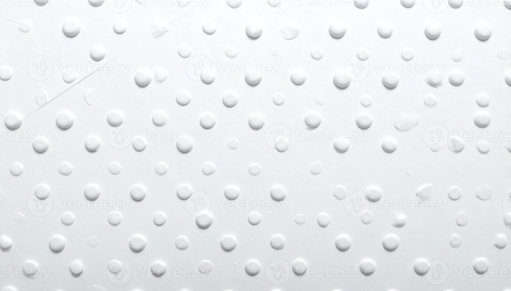 Close-up of a white paper with dotted pattern and textured surface photo