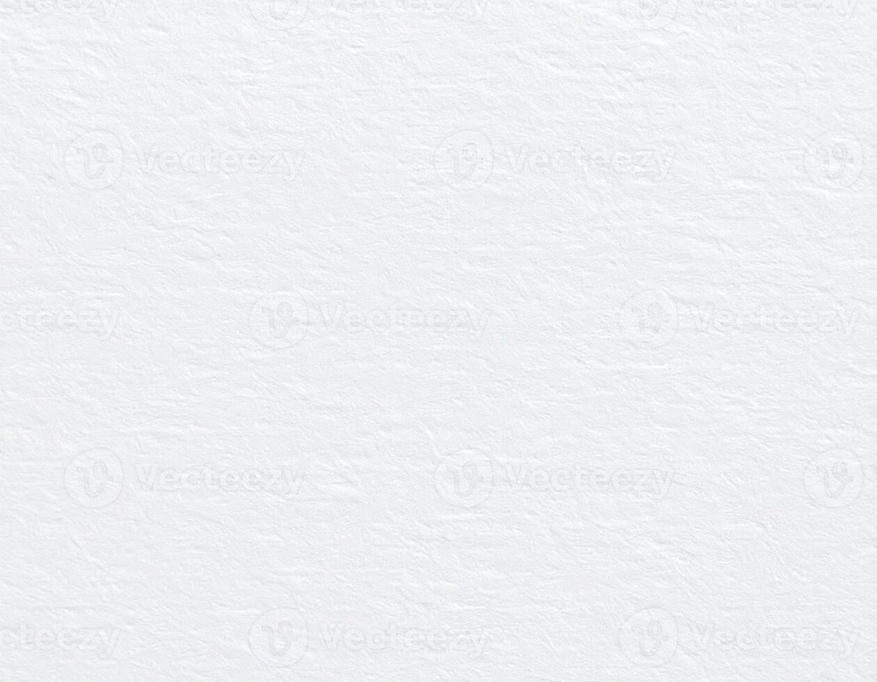 Close-up of a white, coarse paper surface with a textured pattern as the background. photo