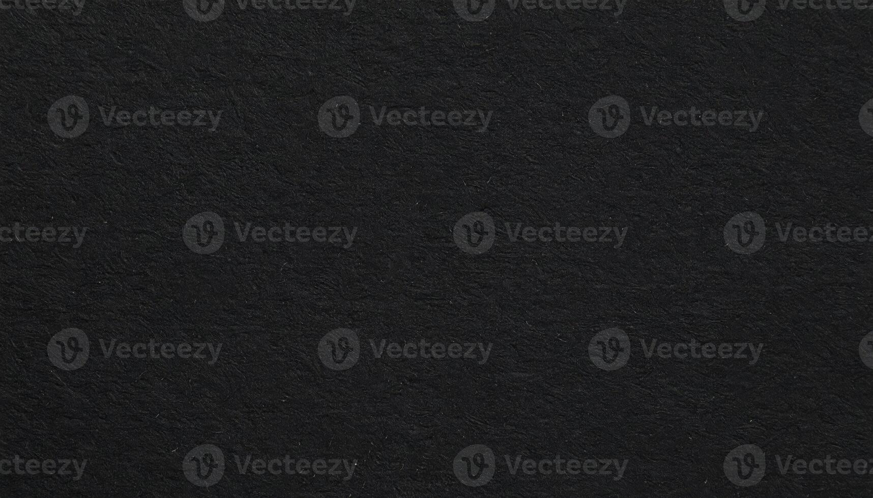 Close-up of a dark, coarse paper surface with textured background pattern photo
