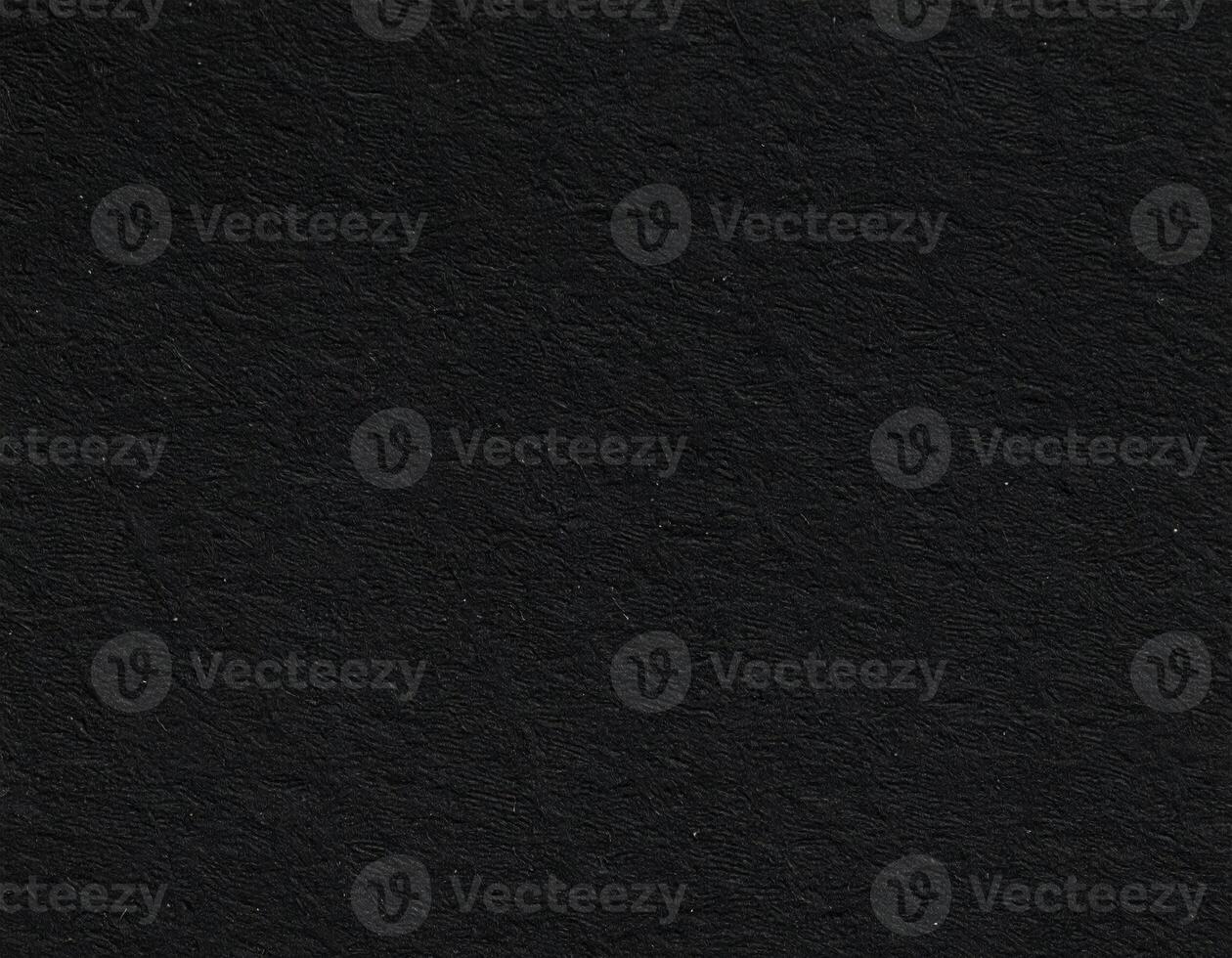 Close-up of a dark, gritty paper surface with textured pattern photo