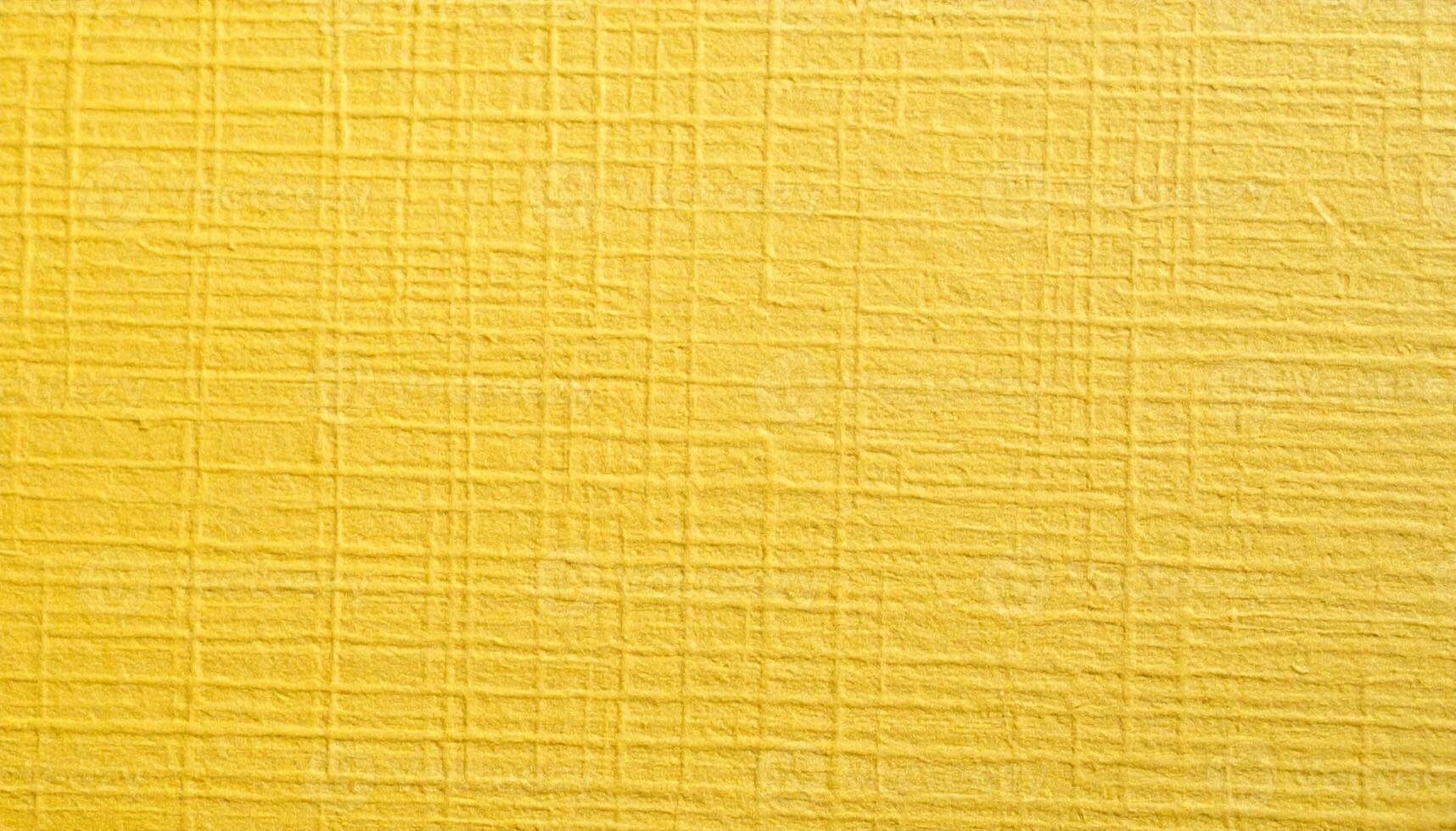 Close-up of a textured, yellow, coarse paper surface with visible patterning photo