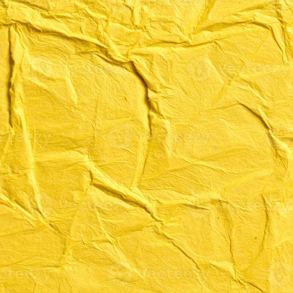 Close-up of a coarse yellow paper surface with a textured pattern in the background photo