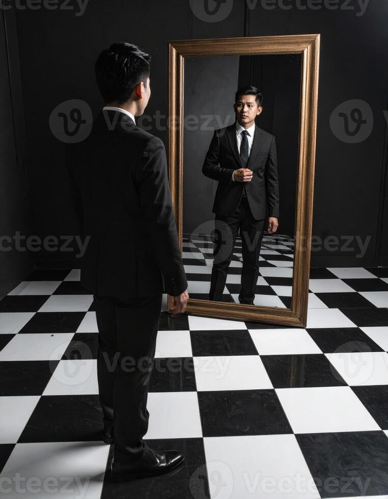 A man dressed in formal attire gazes into a mirror, where a bizarre reflection creates a surreal horror scene on a checkered floor. photo