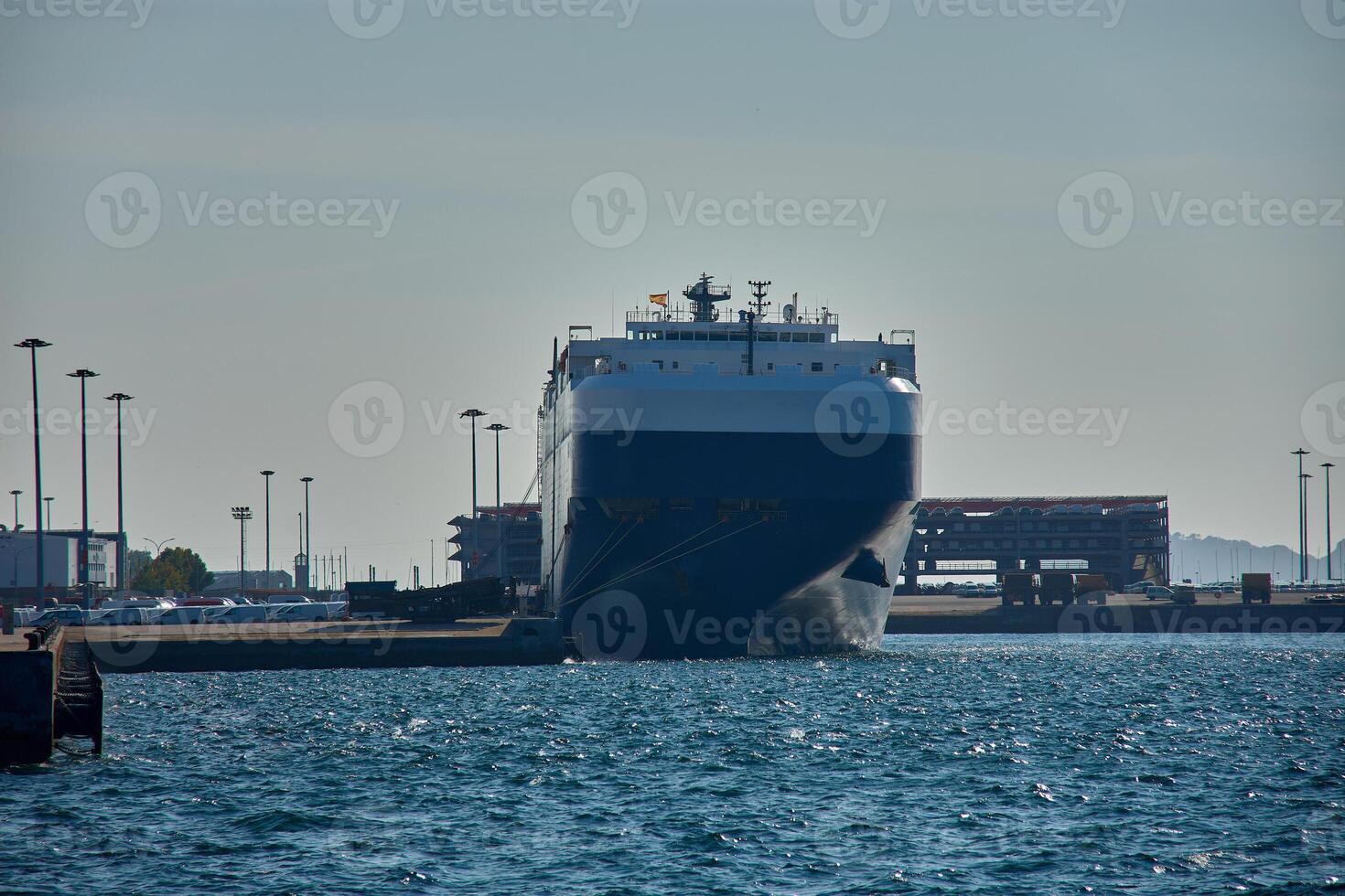 Huge car carrier ship moored in the Galician port of Vigo, with details of port facilities in the background photo