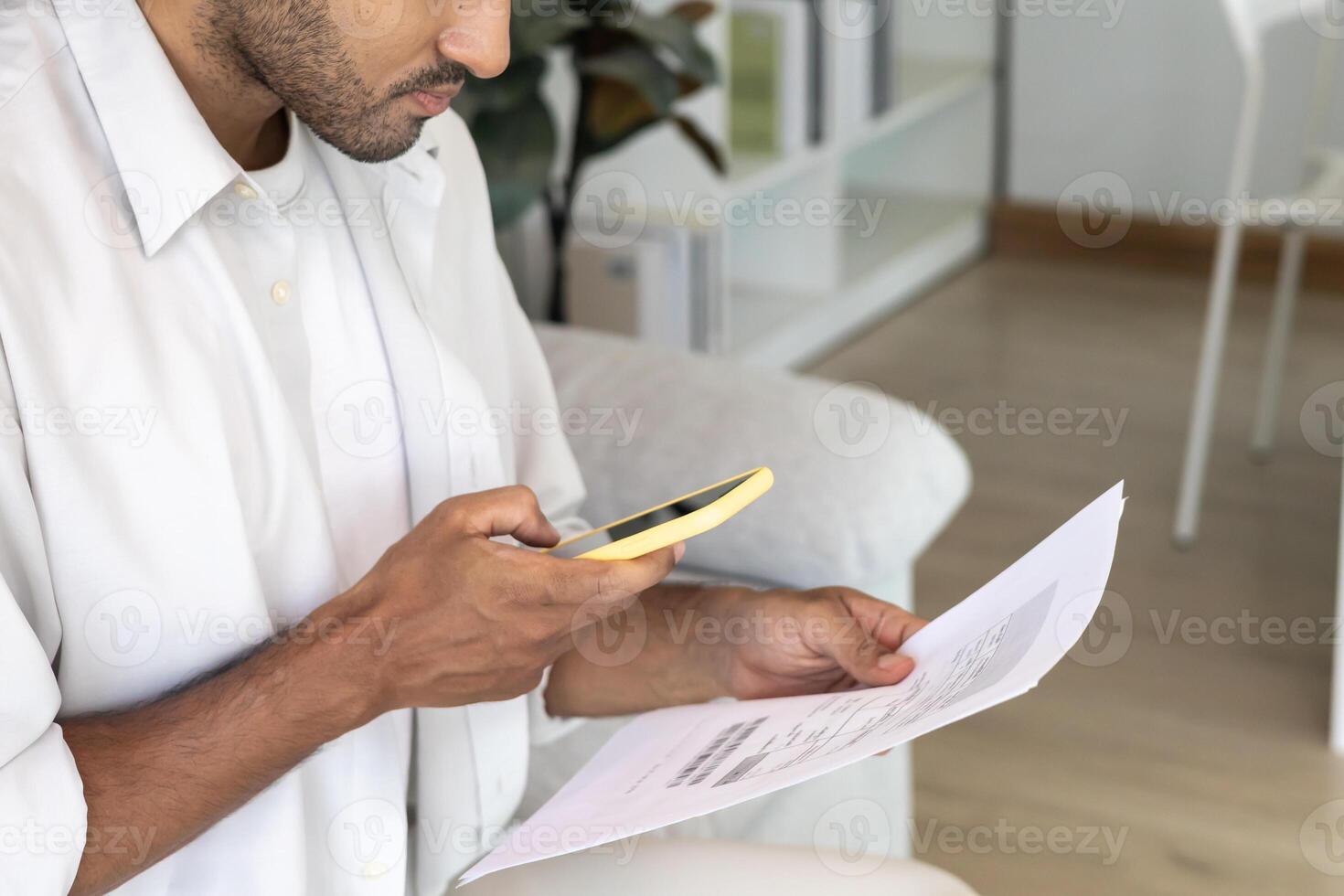 business men use phone to scan barcode or QR codes to pay credit card bill after receiving document invoice online. payment, receive, paying electricity, digital payments without money. photo