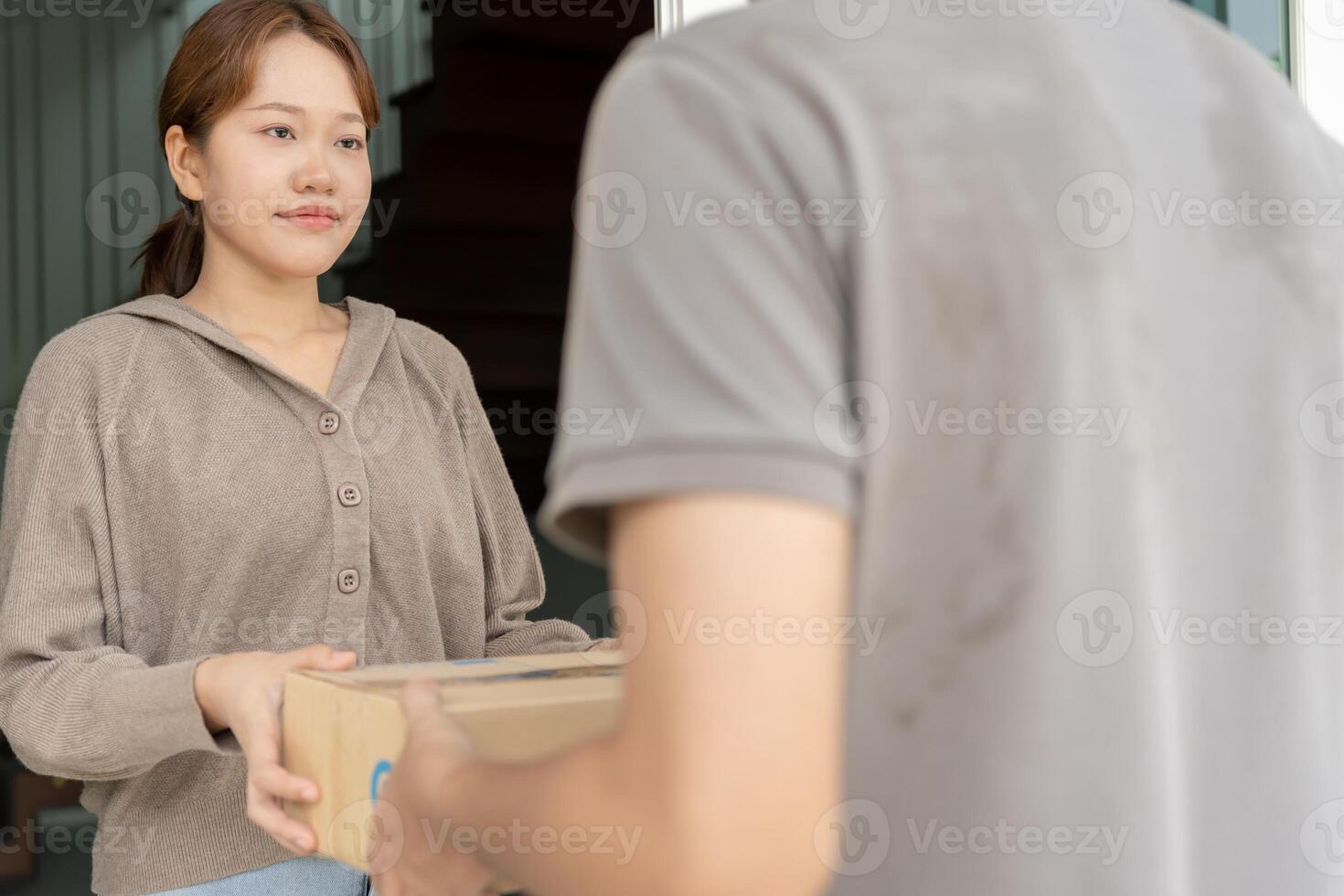 Happy smiling woman receives boxes parcel from courier in front house. Delivery man send deliver express. online shopping, paper containers, takeaway, postman. delivery service, packages photo