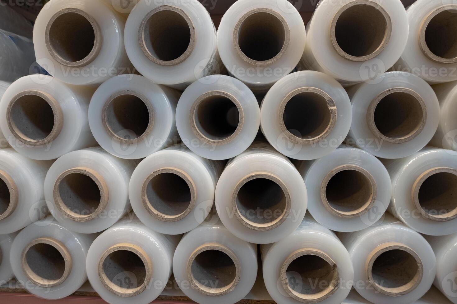 Rolls of transparent plastic wrap stacked neatly in a warehouse showcasing organized storage photo