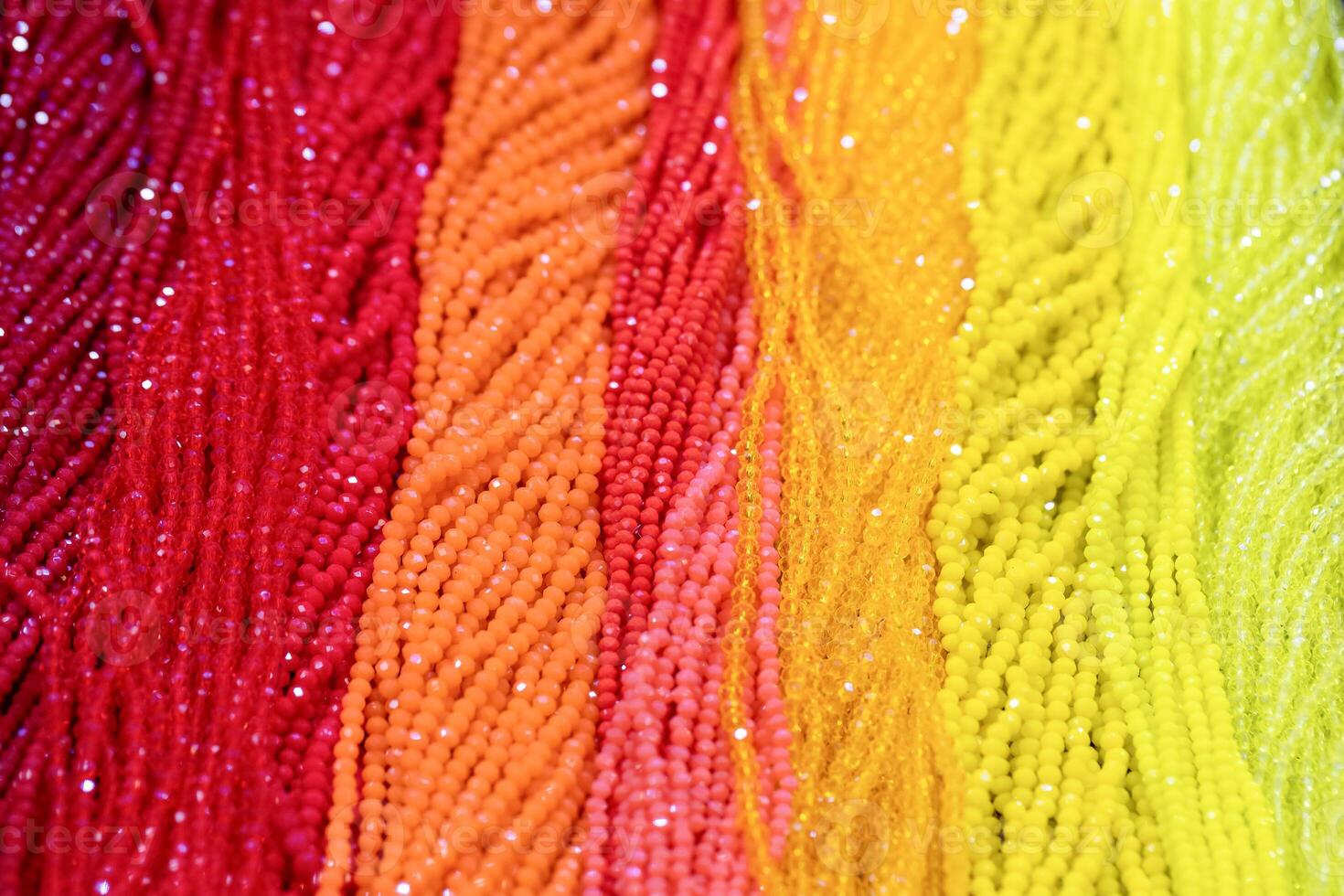 Colorful strands of beads in vibrant hues arranged in a beautiful gradient pattern photo