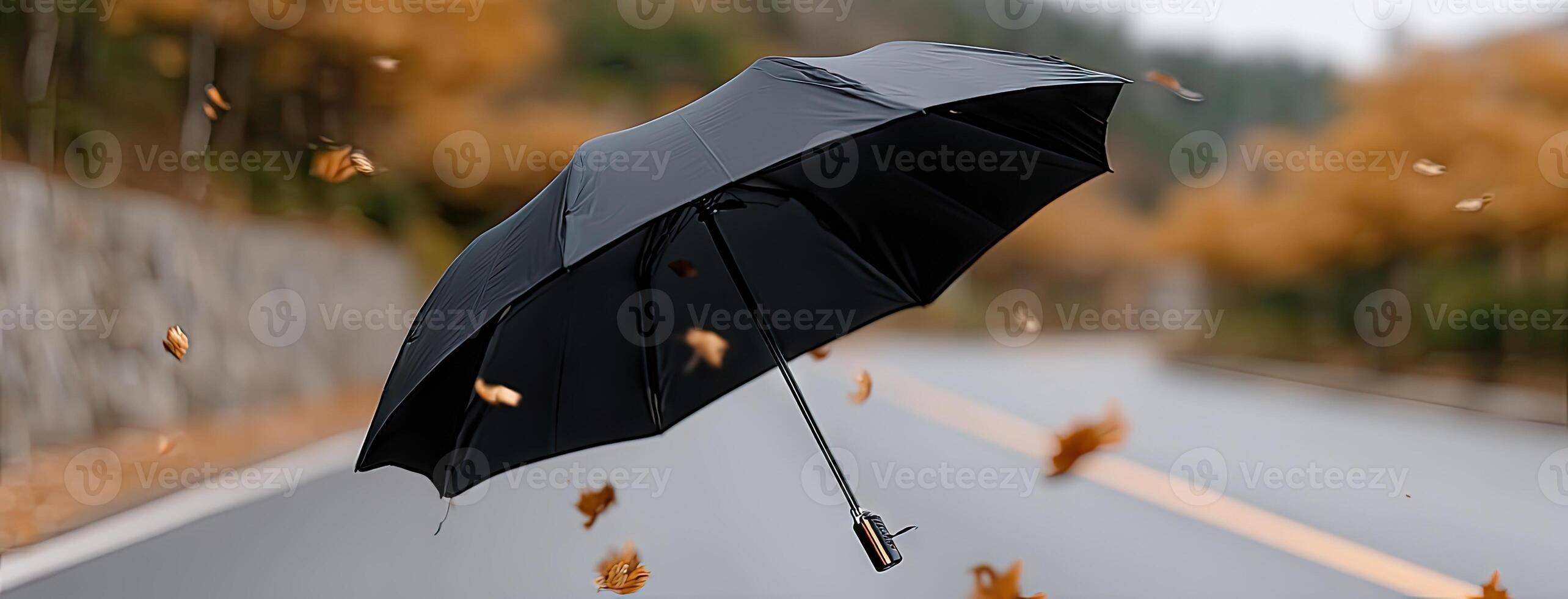 A black umbrella flying in the wind photo