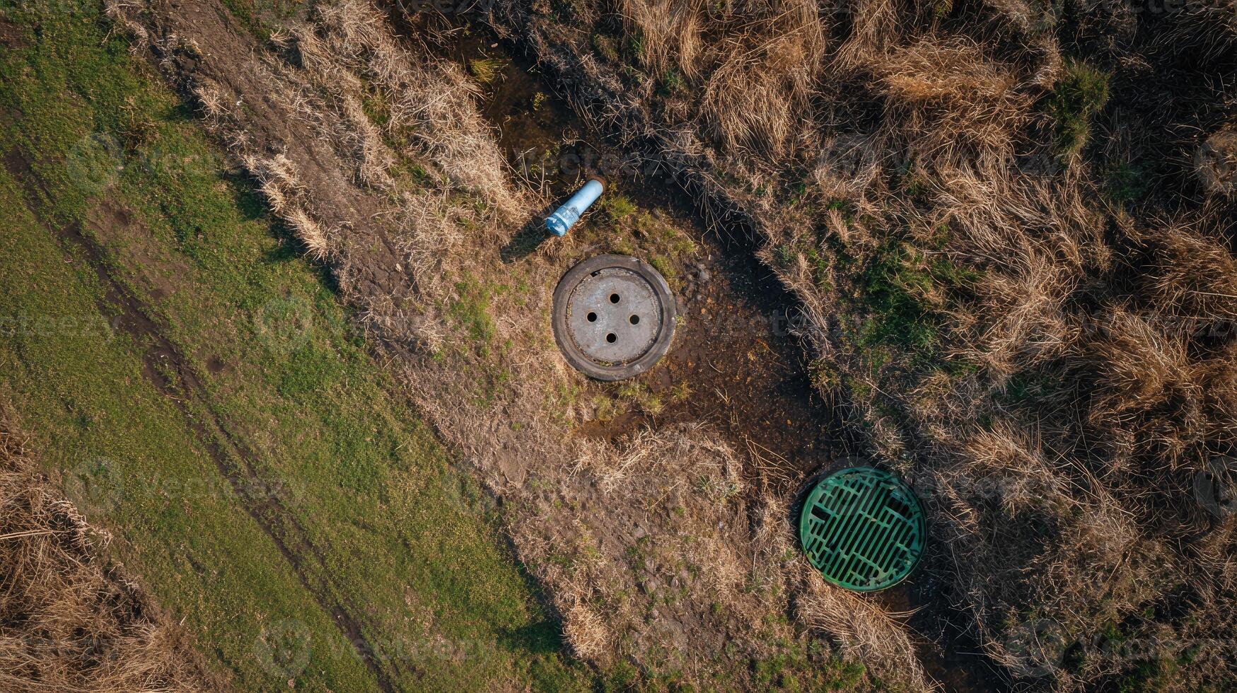 An aerial view of a manhole in the middle of a field photo