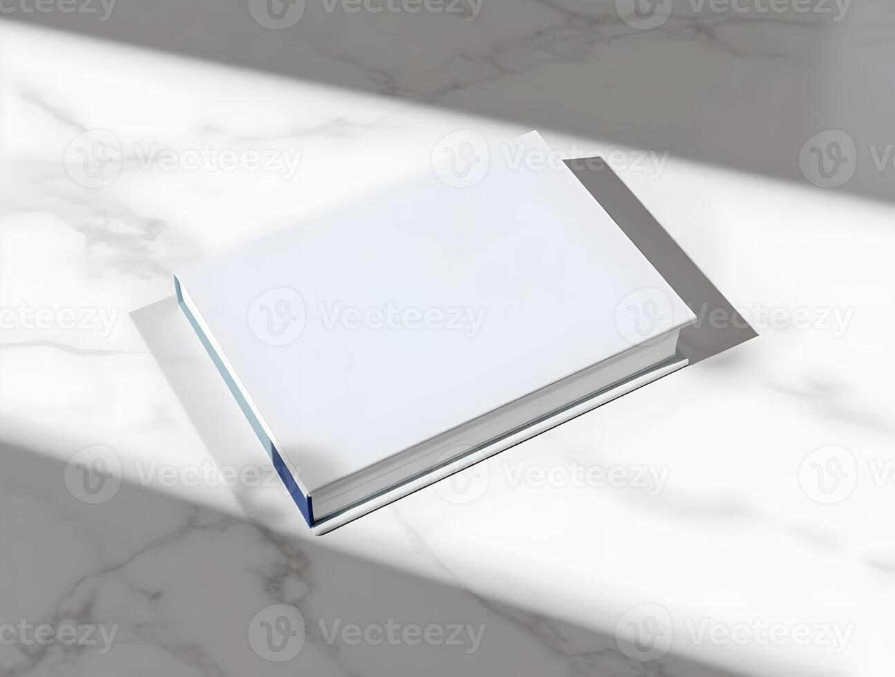 A white book on a marble surface with a shadow photo