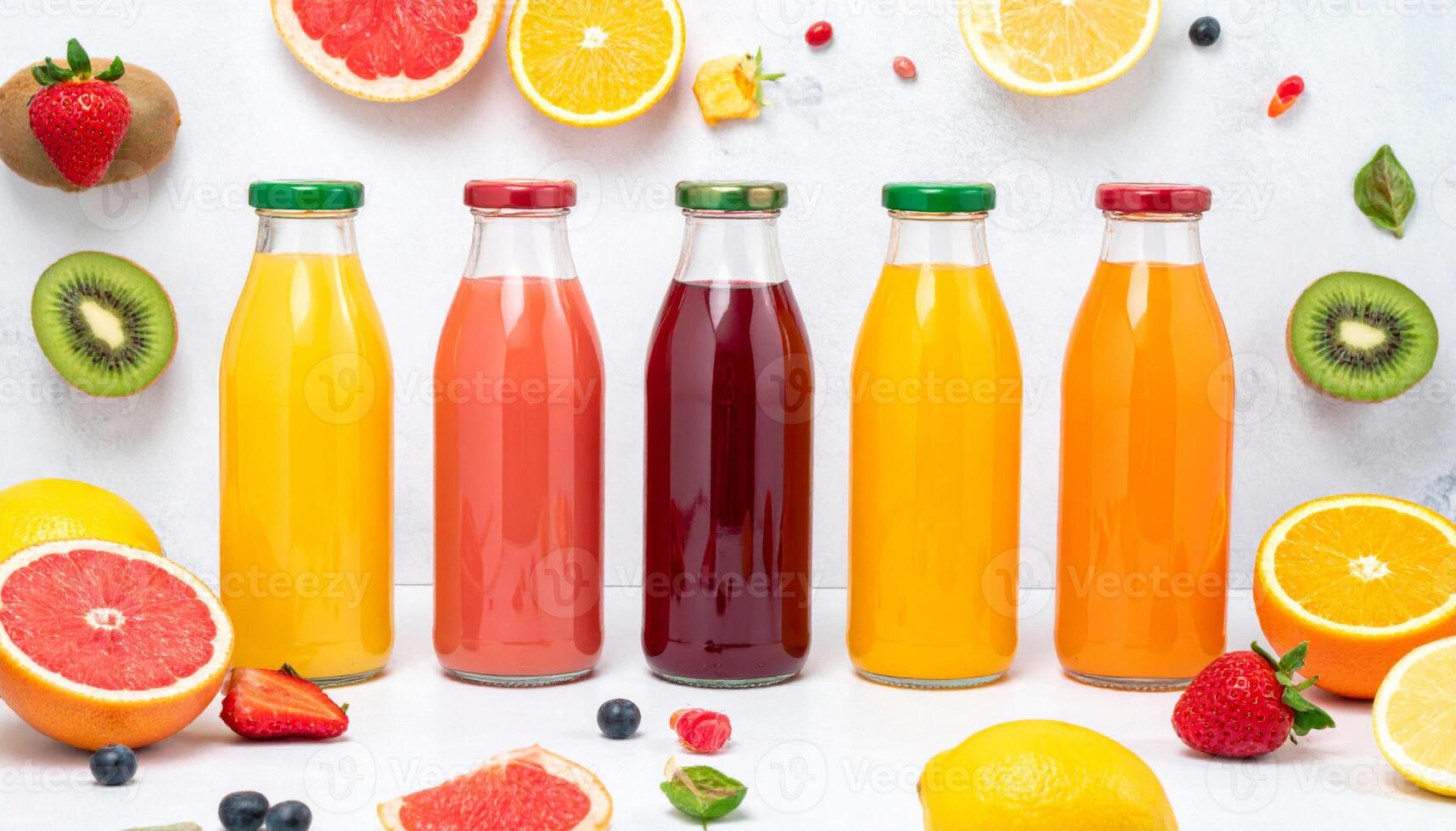 Assorted Fruit Juices in Glass Bottles on White Surface with Sliced Fruits Top View photo