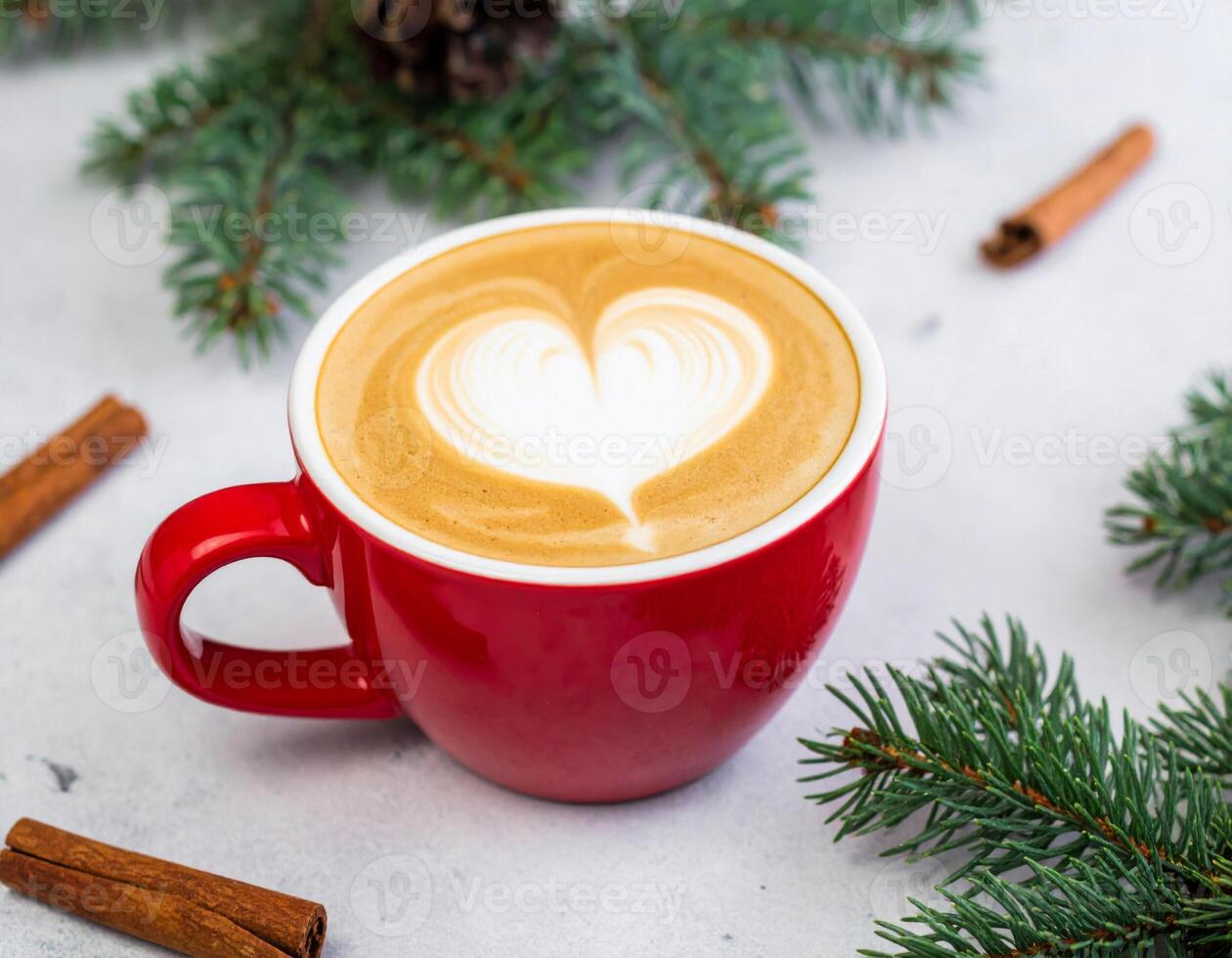Red Coffee Cup with Latte Art in Heart Shape with Cinnamon and Festive Evergreen Branches photo