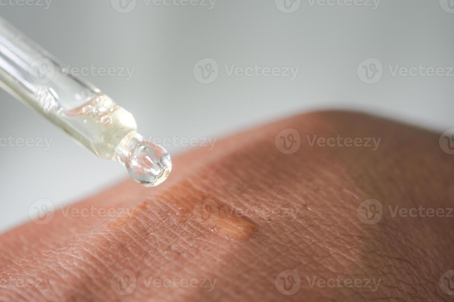 Serum drop falling on skin for skincare routine photo