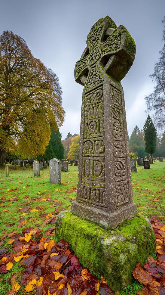 Ancient Celtic Cross Covered In Moss With Autumn Leaves On The Ground. photo
