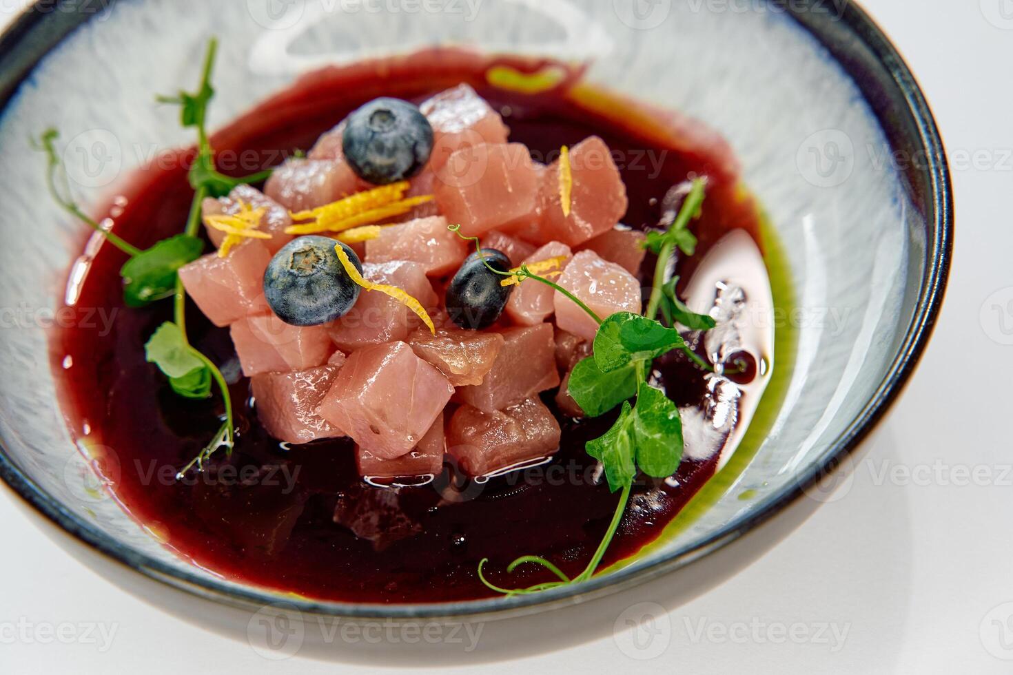 A Gourmet Array of Cubed Ingredients Dressed with Fresh Herbs and Bright Berries in Vibrant Sauce Served in a Stylish Bowl photo